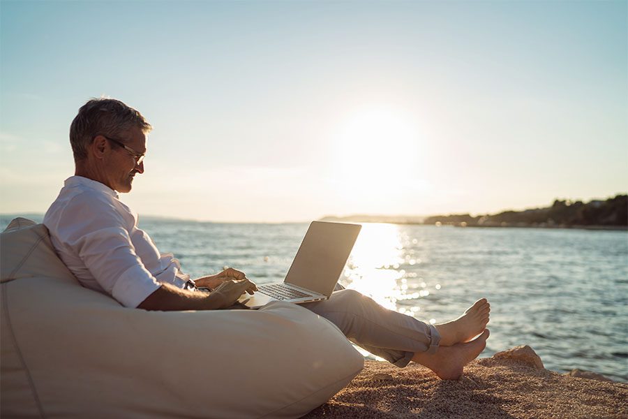 Contact - Mature Man Working on Laptop Outside at the Lake